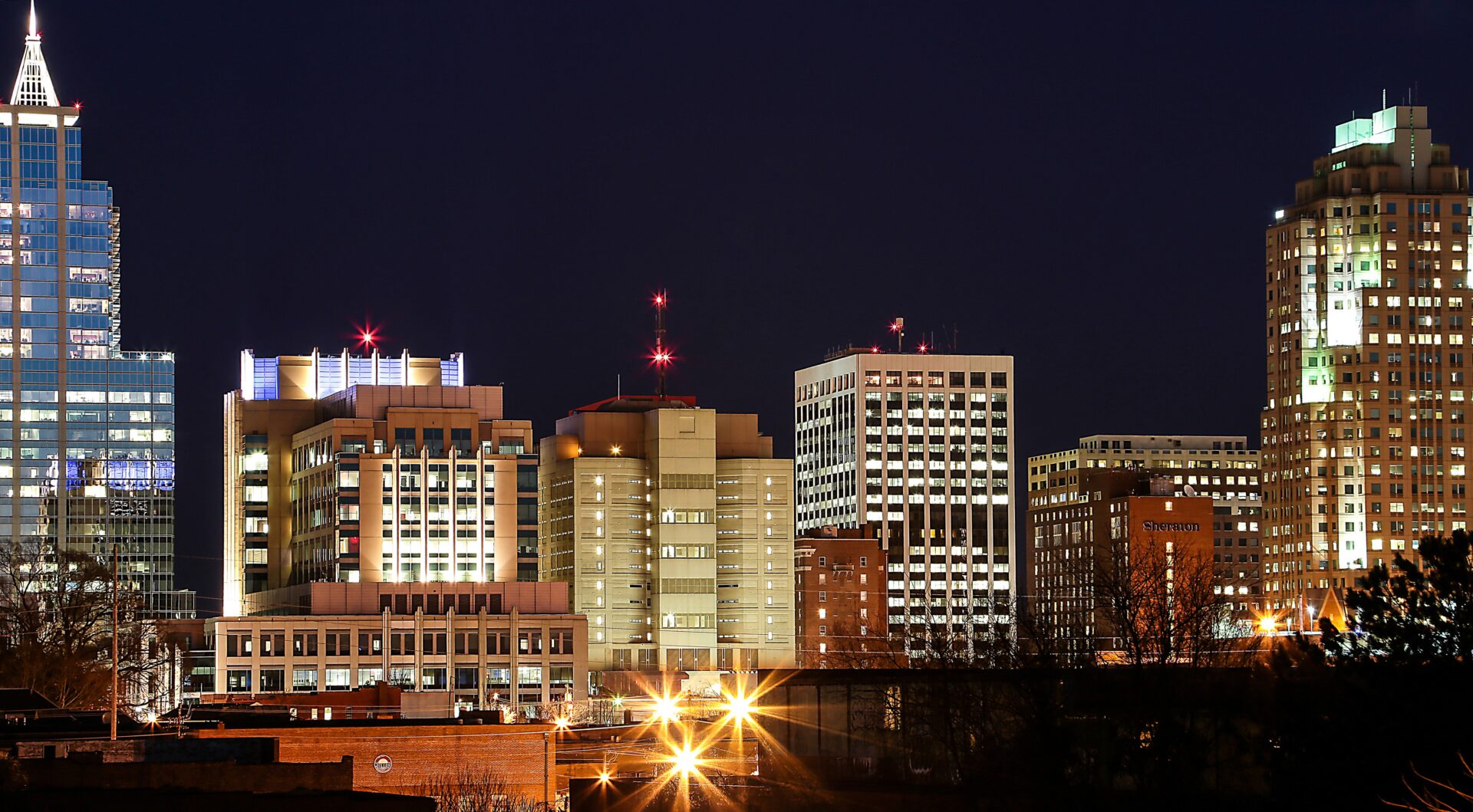 A city skyline with many buildings lit up at night.